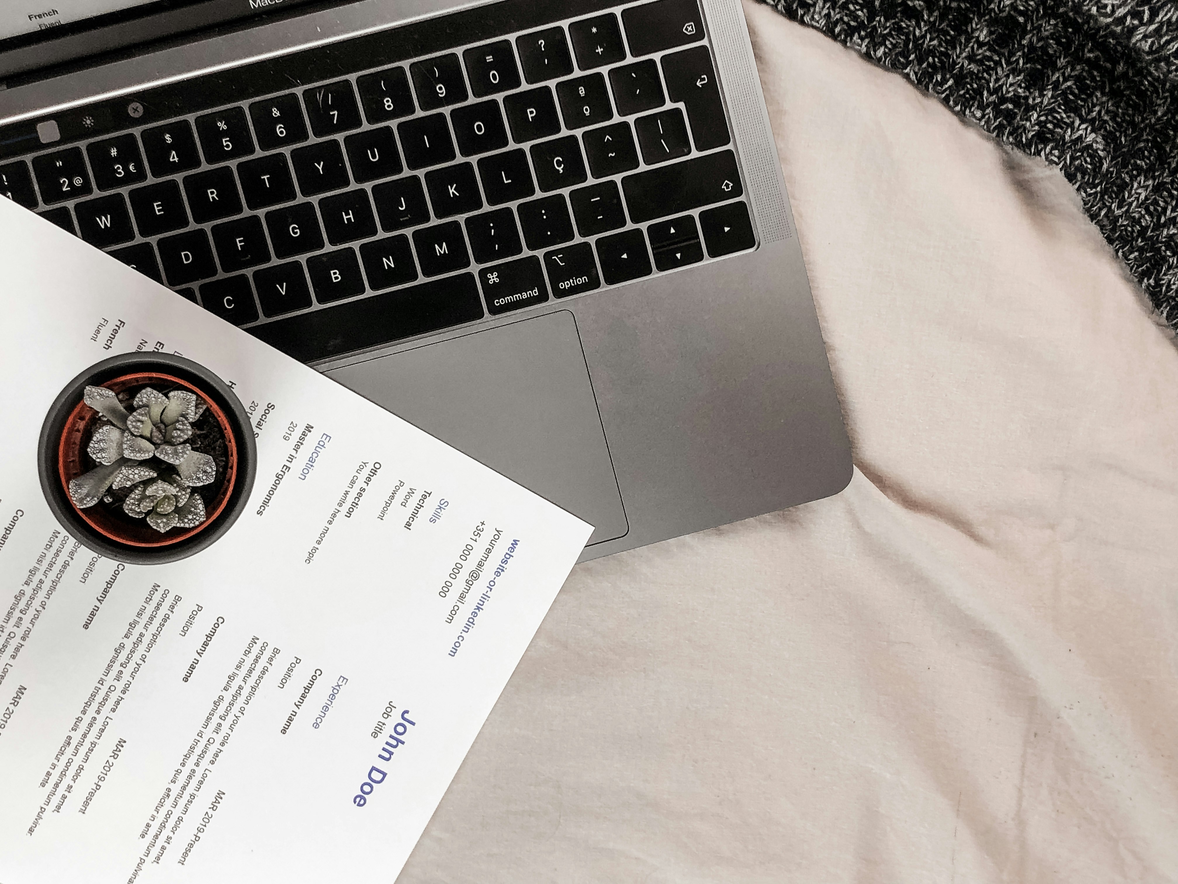 a laptop and resume sitting on bed