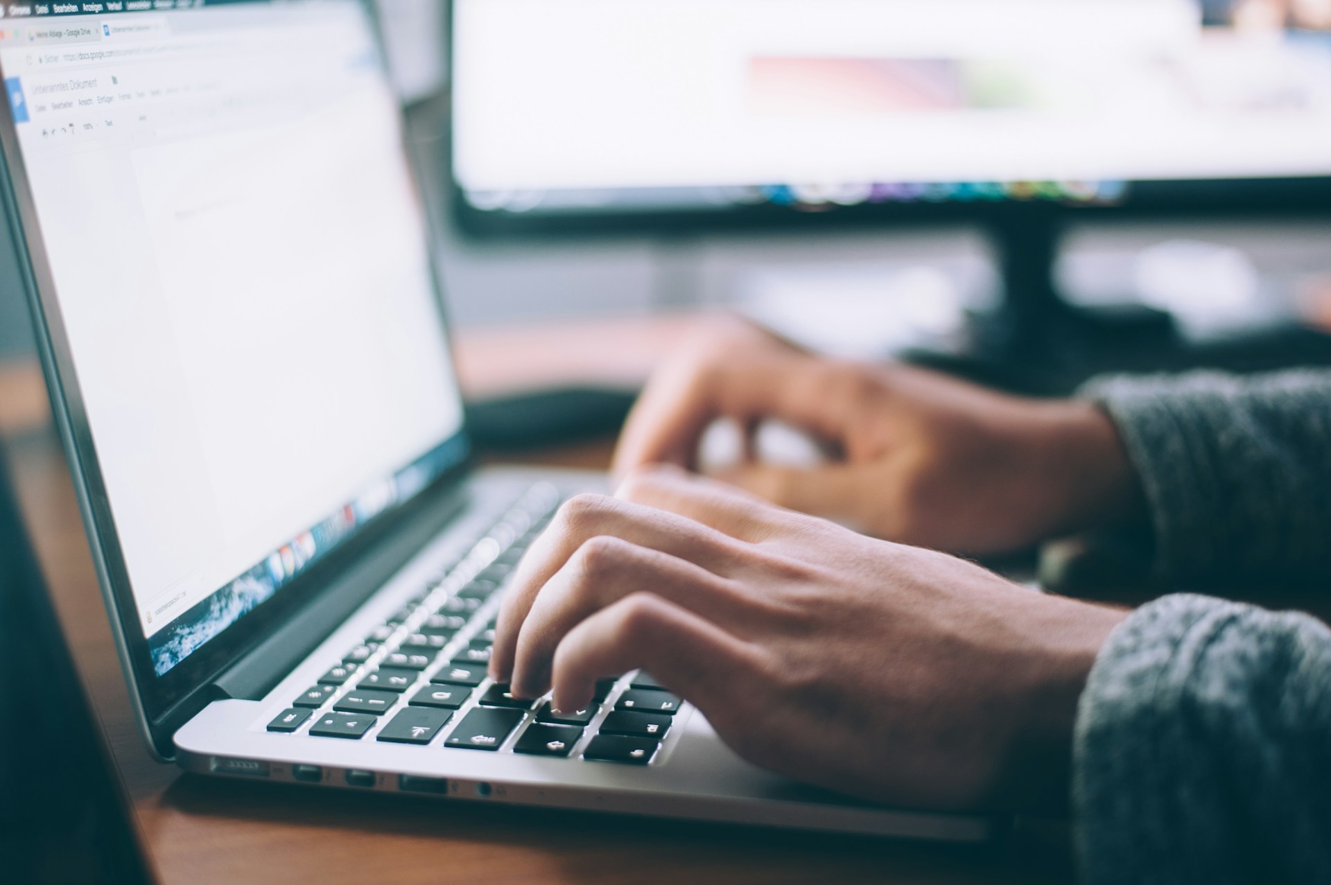 a person typing on their laptop